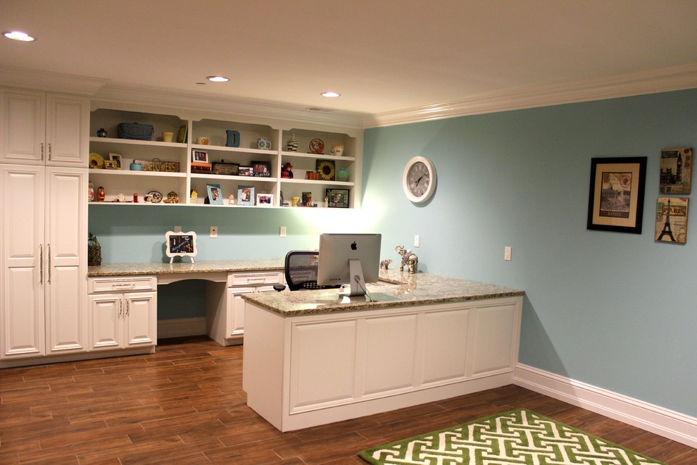 Réalisation d'un bureau tradition avec un mur bleu, un sol en carrelage de porcelaine, un bureau intégré et un sol marron.