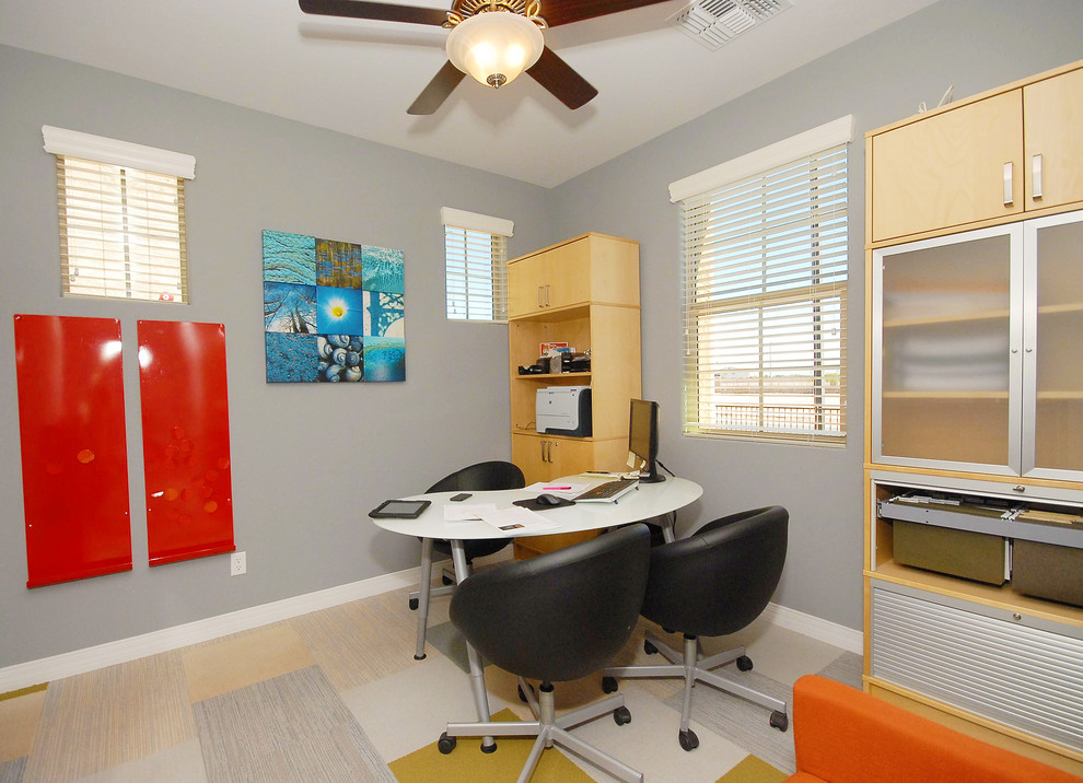 Inredning av ett klassiskt mellanstort arbetsrum, med blå väggar, heltäckningsmatta och ett fristående skrivbord
