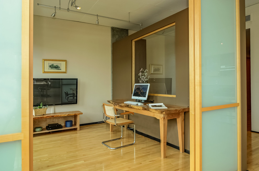 Idee per uno studio minimal con pareti marroni, parquet chiaro, scrivania autoportante e pavimento beige