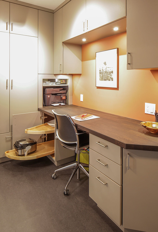 На фото: маленькое рабочее место в современном стиле с оранжевыми стенами, полом из линолеума, встроенным рабочим столом и серым полом без камина для на участке и в саду