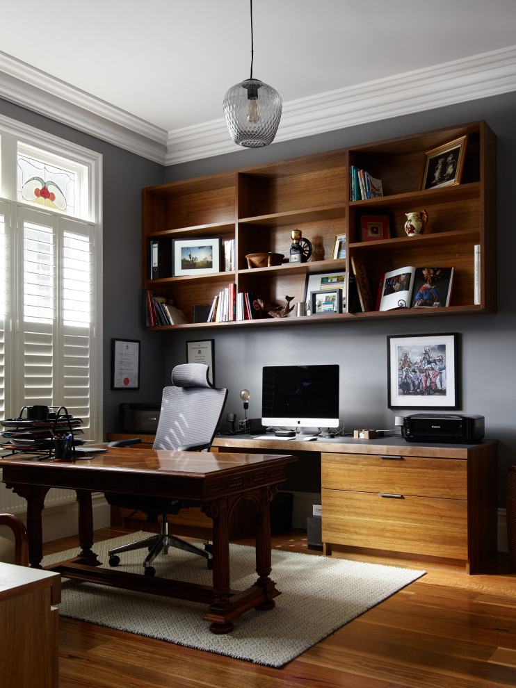 Foto di un ufficio contemporaneo di medie dimensioni con pareti grigie, pavimento in legno massello medio e scrivania autoportante