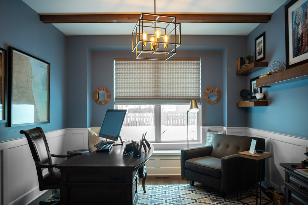 This is an example of a medium sized traditional study in Chicago with blue walls, dark hardwood flooring, no fireplace, a freestanding desk and brown floors.