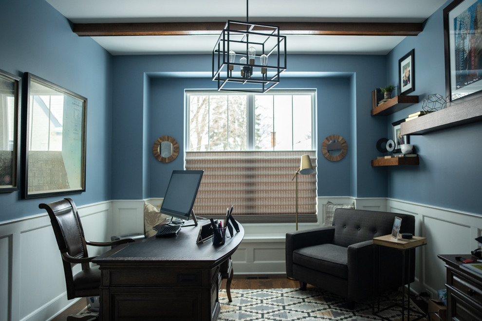 Inspiration för mellanstora klassiska hemmabibliotek, med blå väggar, mörkt trägolv, ett fristående skrivbord och brunt golv