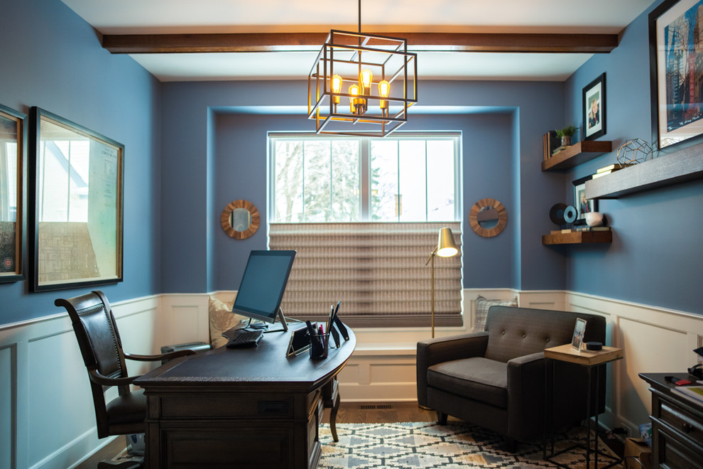 This is an example of a medium sized traditional study in Chicago with blue walls, dark hardwood flooring, no fireplace, a freestanding desk and brown floors.
