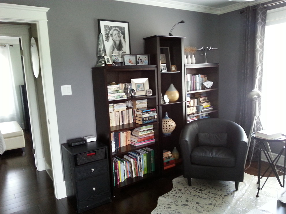 Idéer för ett litet klassiskt hemmabibliotek, med grå väggar, mörkt trägolv och ett fristående skrivbord