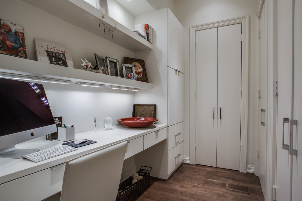 Cette image montre un petit bureau minimaliste avec un mur blanc, parquet foncé, aucune cheminée et un bureau intégré.
