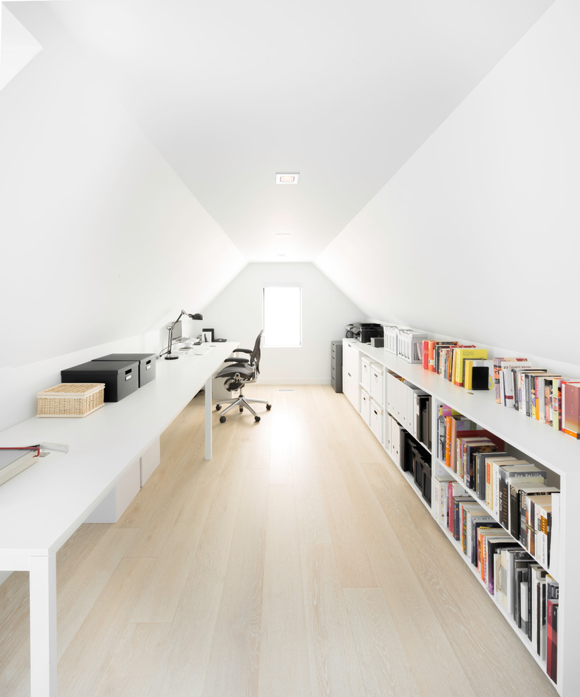 Kleines Modernes Arbeitszimmer mit Arbeitsplatz, weißer Wandfarbe, hellem Holzboden und freistehendem Schreibtisch in Toronto