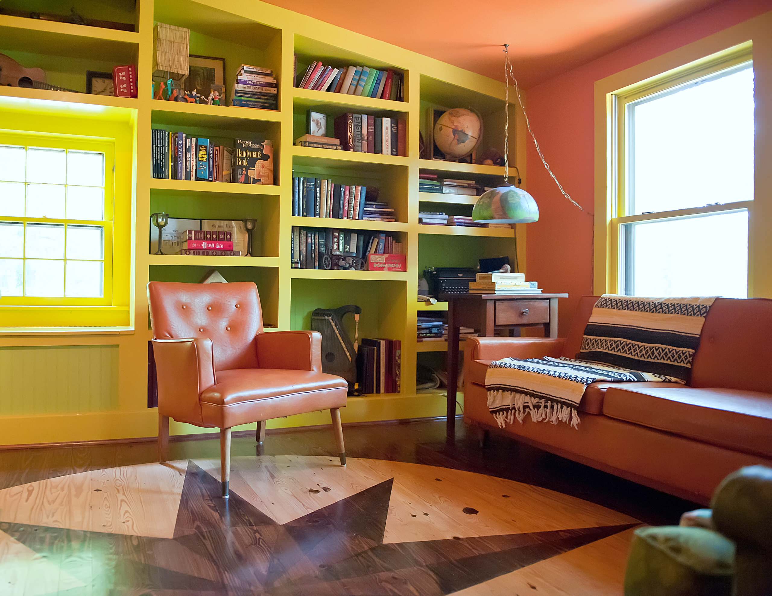 modern-small-man-cave-ideas-orange-leather-sofa-open-shelves - Decorology