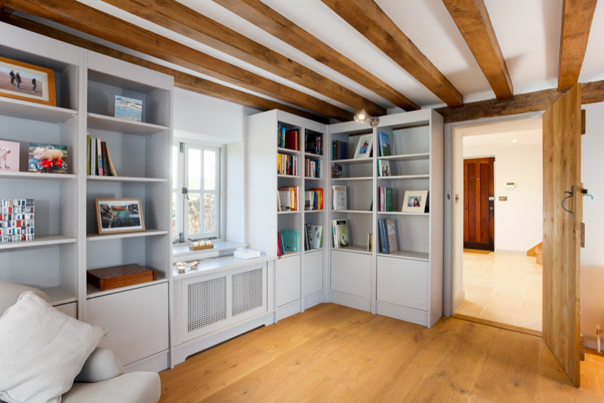 Inspiration för ett stort lantligt arbetsrum, med ett bibliotek, blå väggar, mellanmörkt trägolv, en öppen vedspis, en spiselkrans i tegelsten, ett inbyggt skrivbord och beiget golv