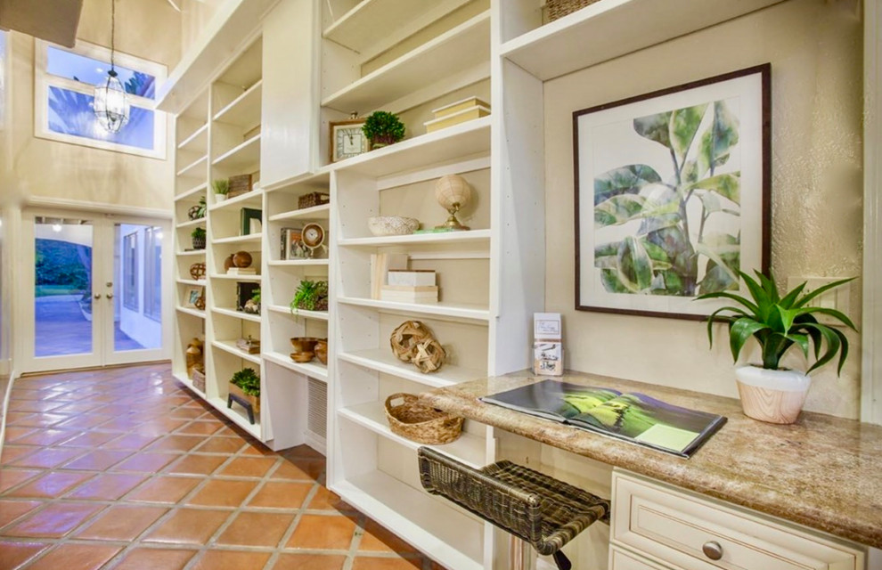Mittelgroßes Mediterranes Lesezimmer mit weißer Wandfarbe, Terrakottaboden, Einbau-Schreibtisch und orangem Boden in San Diego