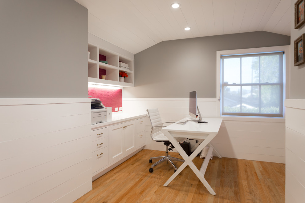 Modelo de despacho contemporáneo con suelo de madera en tonos medios y escritorio independiente