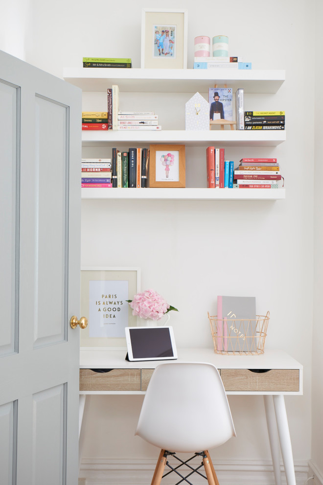Photo of a medium sized scandi home office in London with white walls and a freestanding desk.