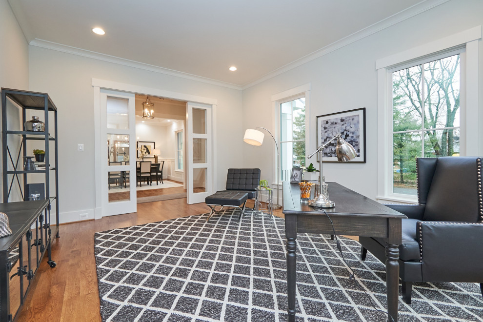 ワシントンD.C.にある高級な広いトランジショナルスタイルのおしゃれなホームオフィス・書斎 (白い壁、無垢フローリング、自立型机、茶色い床) の写真