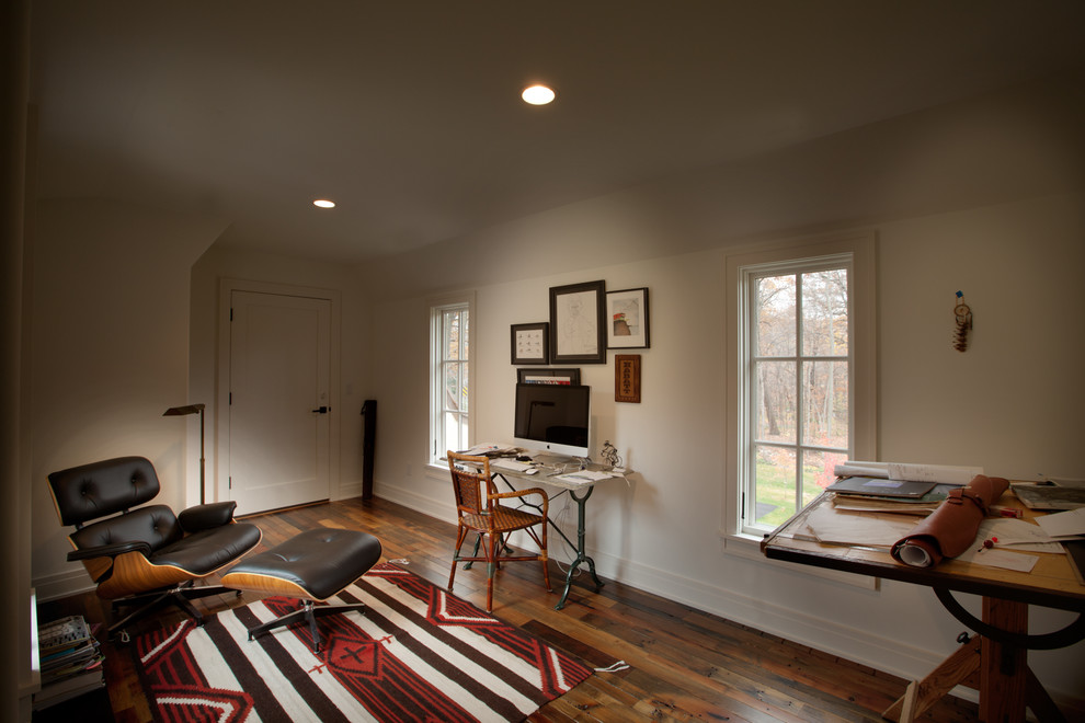 This is an example of a traditional home studio in Minneapolis with white walls, dark hardwood flooring and a freestanding desk.