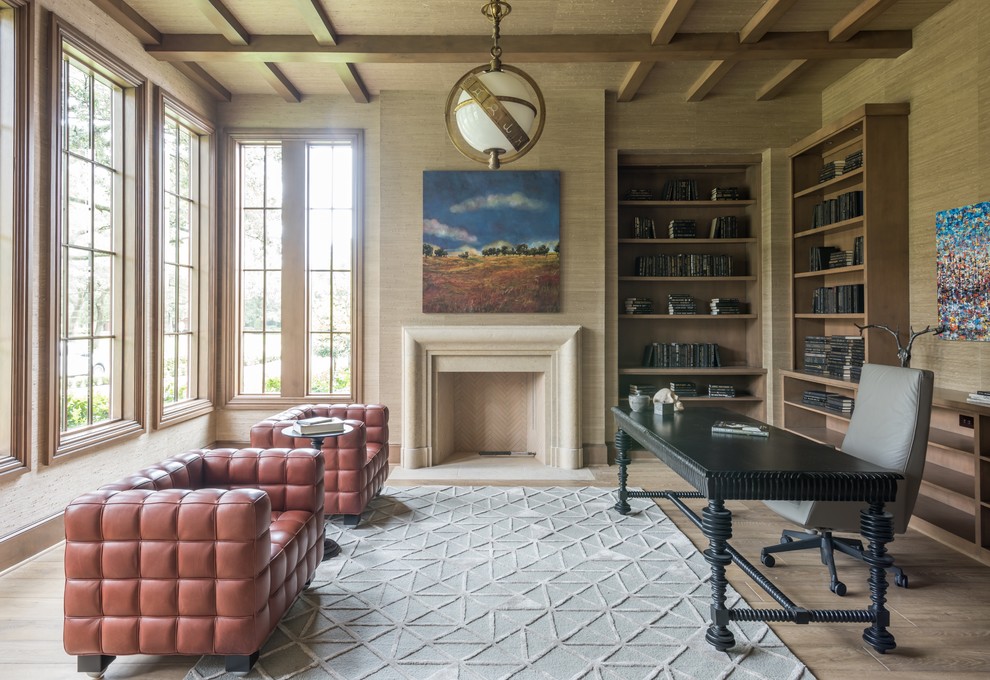 Exempel på ett stort klassiskt hemmabibliotek, med mörkt trägolv, en standard öppen spis, ett fristående skrivbord, brunt golv och beige väggar
