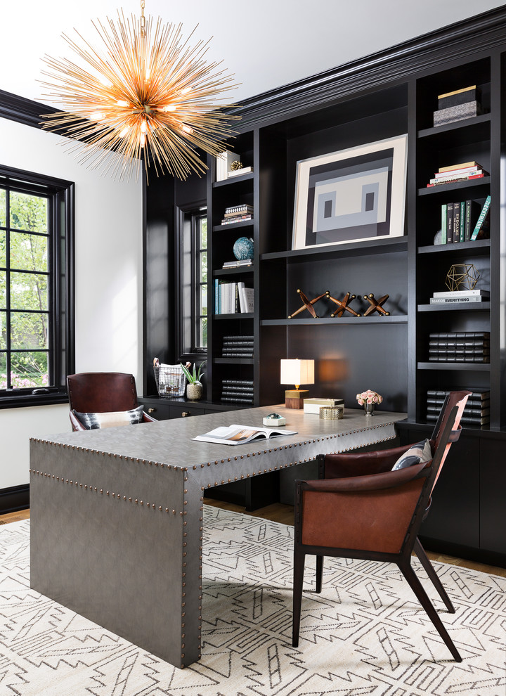 Inspiration for a large transitional built-in desk medium tone wood floor and brown floor home office remodel in Detroit with black walls