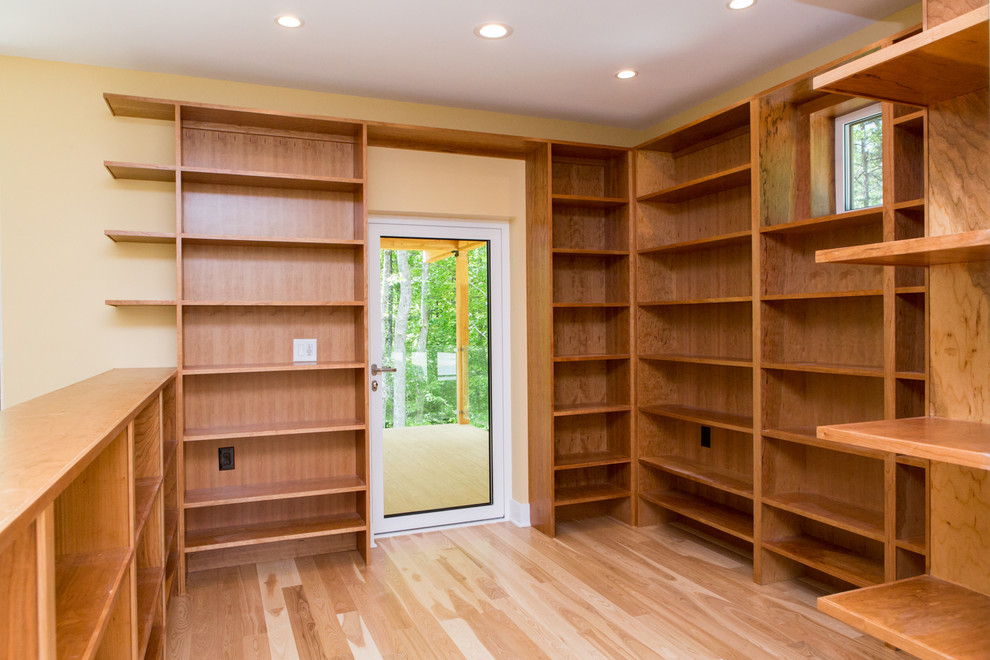 Imagen de despacho moderno de tamaño medio con biblioteca, paredes beige y suelo de madera en tonos medios