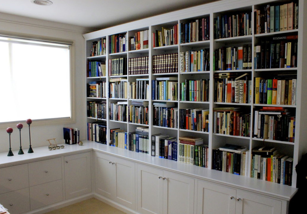 Immagine di un piccolo studio minimal con libreria, moquette, nessun camino e scrivania incassata