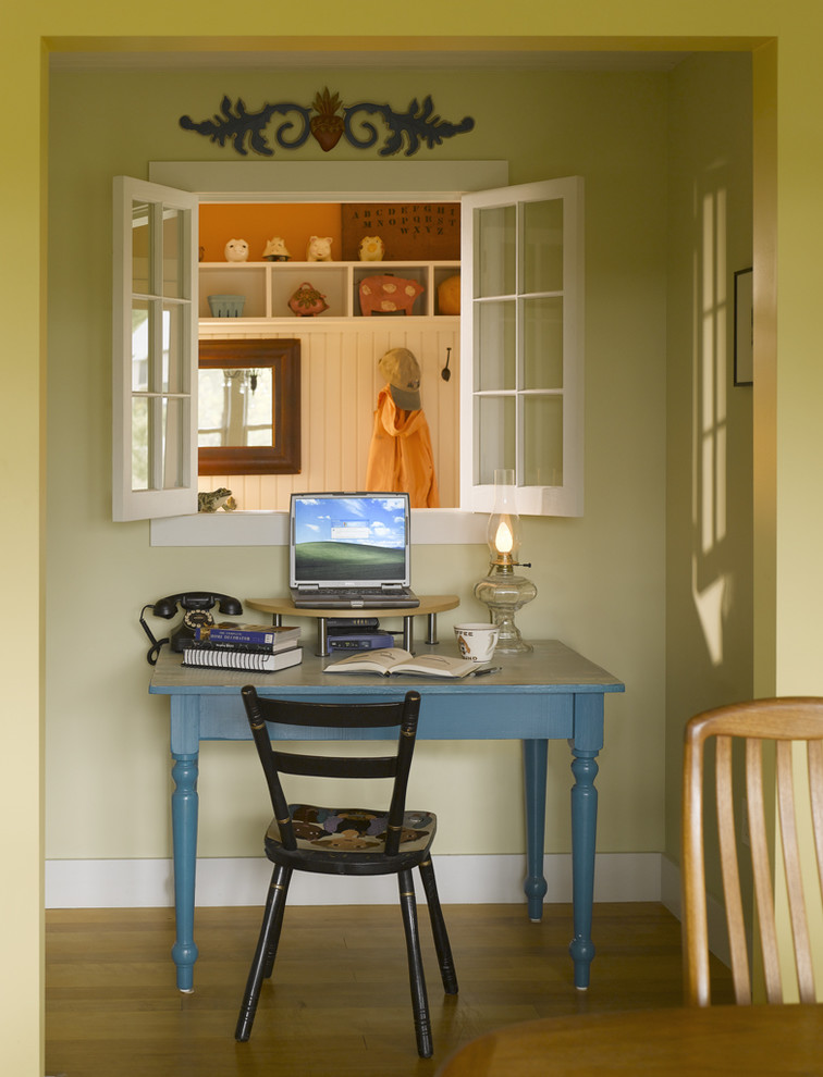 Cette image montre un bureau rustique avec un mur vert, un sol en bois brun et un bureau indépendant.