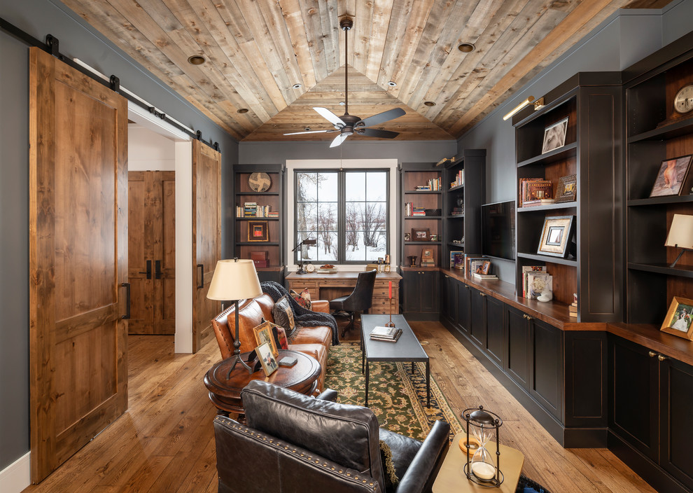 Imagen de despacho de estilo de casa de campo con paredes grises, suelo de madera en tonos medios, escritorio independiente y suelo marrón
