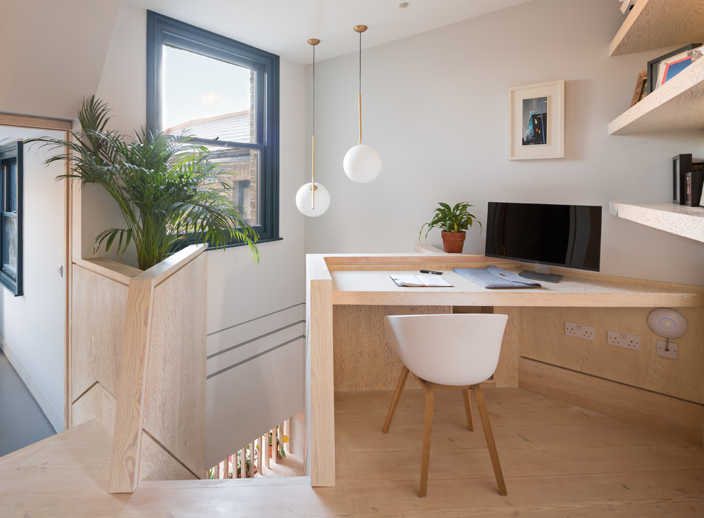 Inspiration for a medium sized contemporary home office in London with multi-coloured walls, plywood flooring, a built-in desk and brown floors.