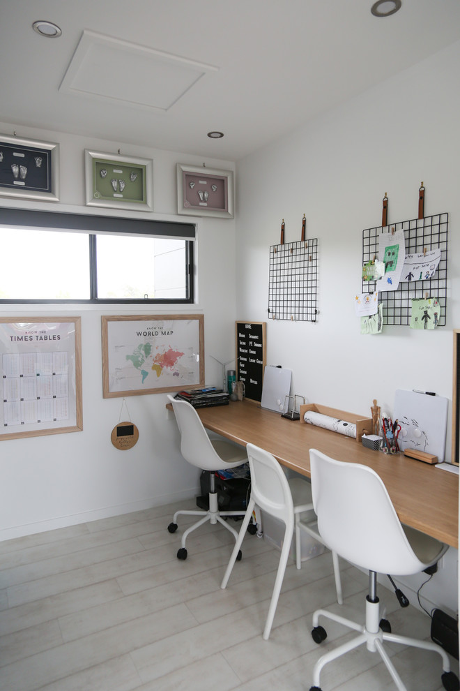 Foto di uno studio minimal con pareti bianche, parquet chiaro, scrivania incassata e pavimento beige