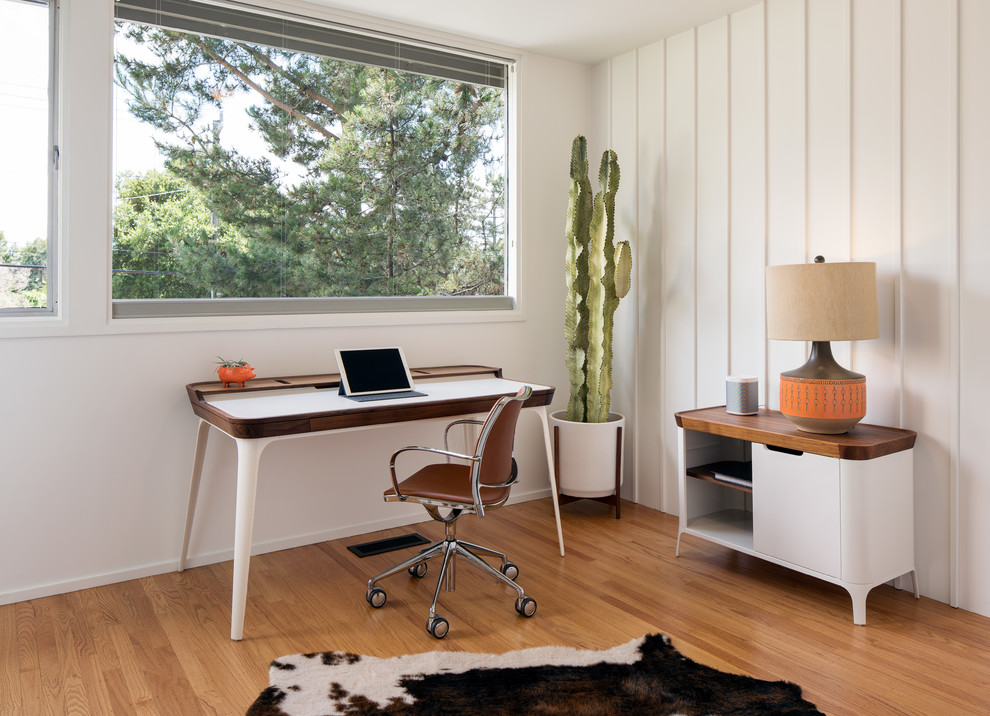 サンフランシスコにある小さなミッドセンチュリースタイルのおしゃれな書斎 (無垢フローリング、茶色い床、白い壁、自立型机、暖炉なし) の写真