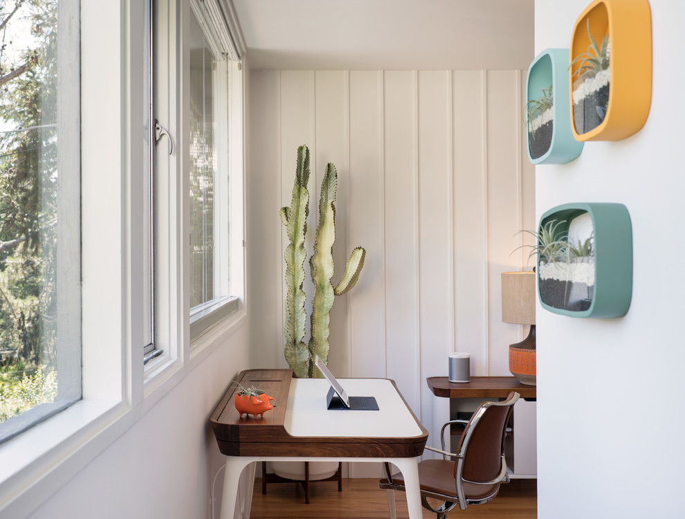 Diseño de despacho retro de tamaño medio sin chimenea con paredes blancas, suelo de madera en tonos medios, escritorio independiente y suelo marrón