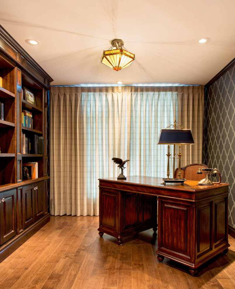This is an example of a traditional home office in Vancouver with medium hardwood flooring and a freestanding desk.