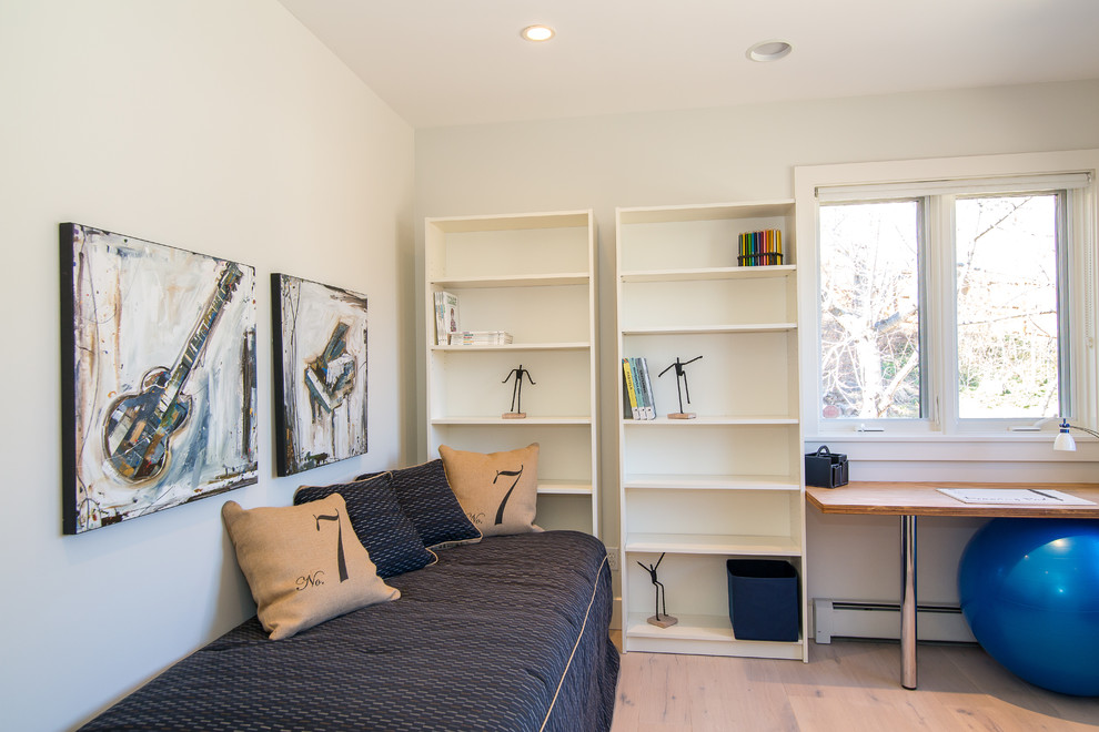 Modelo de despacho minimalista de tamaño medio con paredes blancas, suelo de madera clara, escritorio independiente y suelo beige