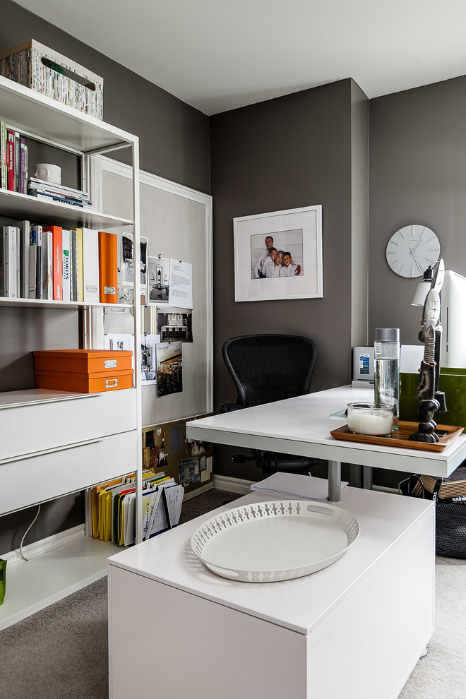 На фото: кабинет в стиле неоклассика (современная классика) с серыми стенами, ковровым покрытием и отдельно стоящим рабочим столом