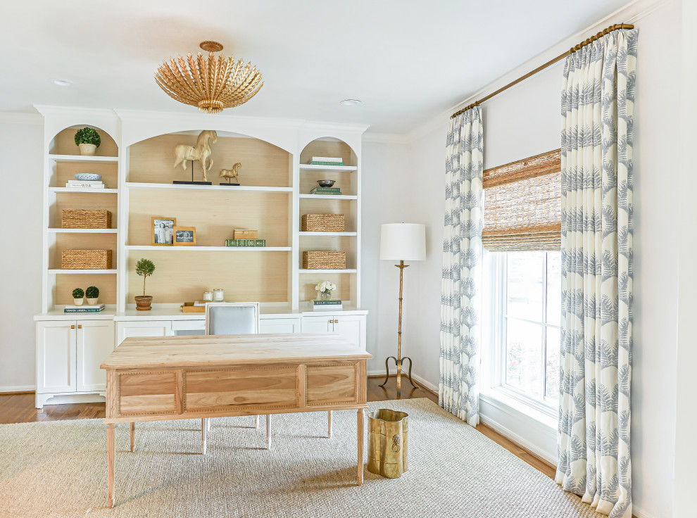 Ejemplo de despacho clásico renovado de tamaño medio con paredes blancas, suelo de madera en tonos medios, escritorio independiente y suelo marrón