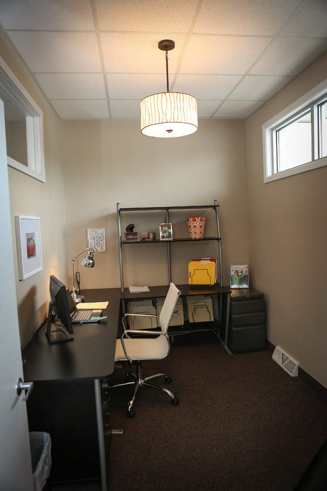 Foto di un piccolo atelier minimal con pareti beige, moquette e scrivania autoportante