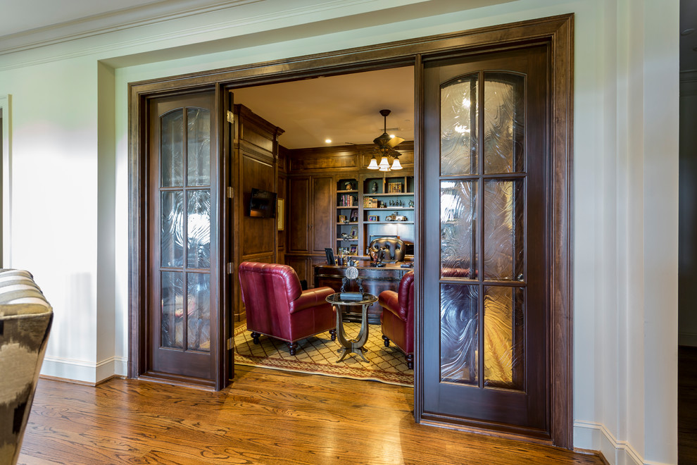 Mittelgroßes Klassisches Lesezimmer mit brauner Wandfarbe, braunem Holzboden, freistehendem Schreibtisch und braunem Boden in Charlotte