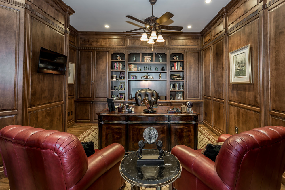 シャーロットにある高級な中くらいなトラディショナルスタイルのおしゃれなホームオフィス・書斎 (ライブラリー、茶色い壁、無垢フローリング、自立型机、茶色い床) の写真