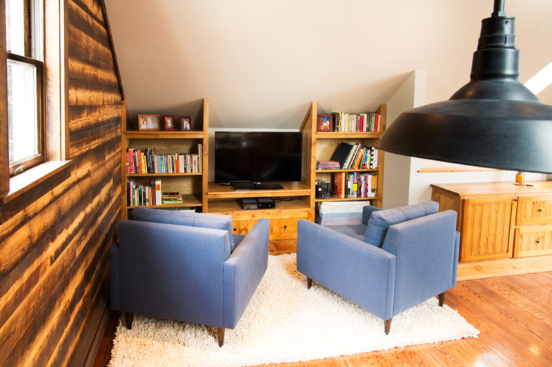 Exempel på ett rustikt arbetsrum, med ett bibliotek, vita väggar, mellanmörkt trägolv, en öppen vedspis, en spiselkrans i sten, ett fristående skrivbord och brunt golv