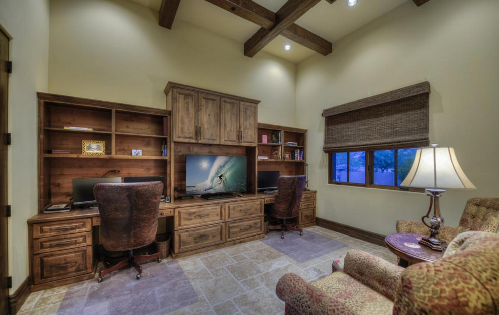 Example of a huge built-in desk travertine floor study room design in Phoenix with beige walls and no fireplace