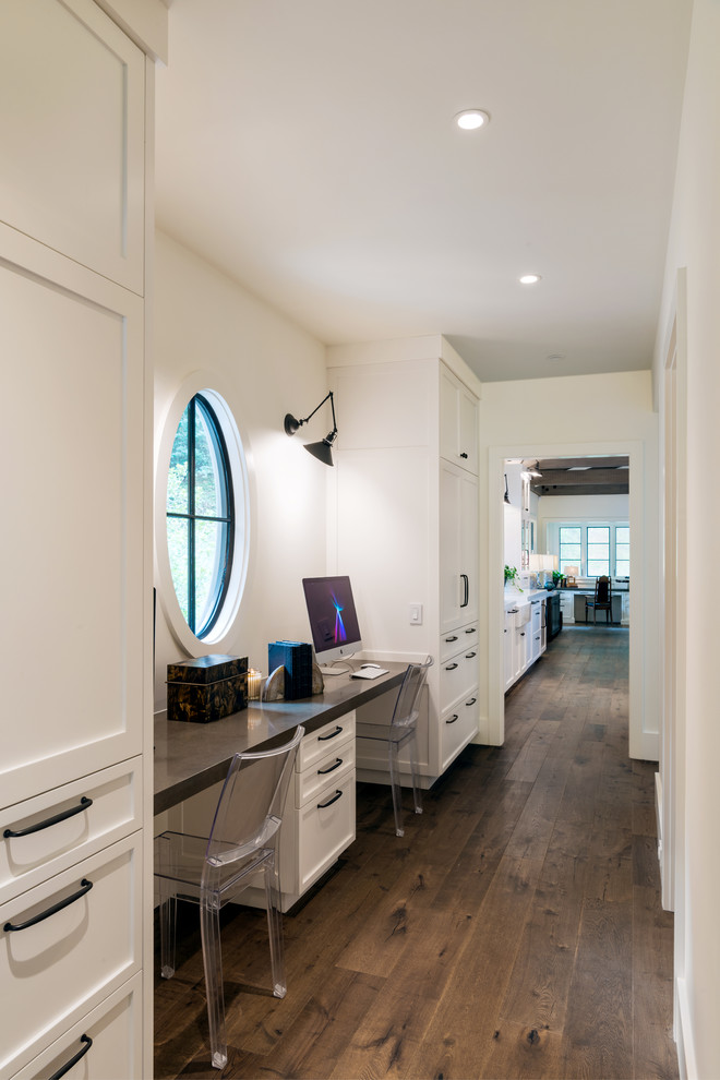 Mid-sized farmhouse built-in desk dark wood floor study room photo in San Francisco with white walls