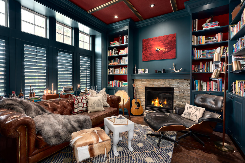 バンクーバーにあるお手頃価格の中くらいなトランジショナルスタイルのおしゃれなホームオフィス・書斎 (ライブラリー、青い壁、濃色無垢フローリング、標準型暖炉、石材の暖炉まわり、茶色い床) の写真