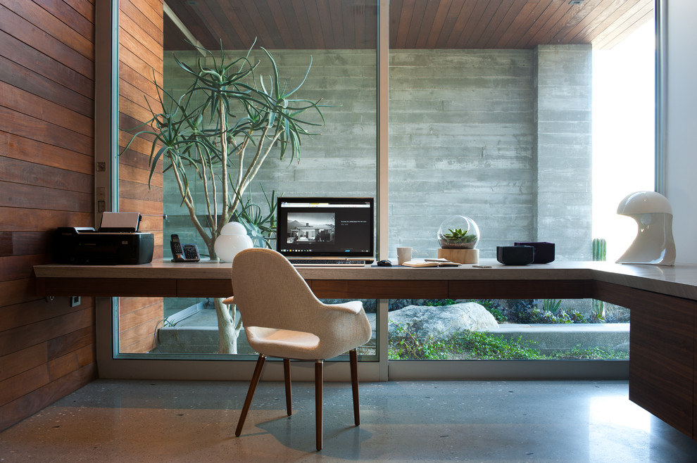 На фото: кабинет в стиле модернизм с бетонным полом и встроенным рабочим столом с