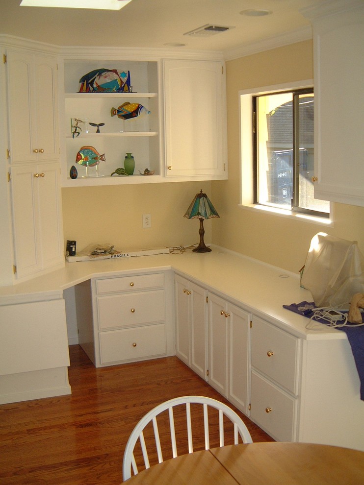 Kleines Modernes Arbeitszimmer mit Studio, gelber Wandfarbe, braunem Holzboden und Einbau-Schreibtisch in Sacramento