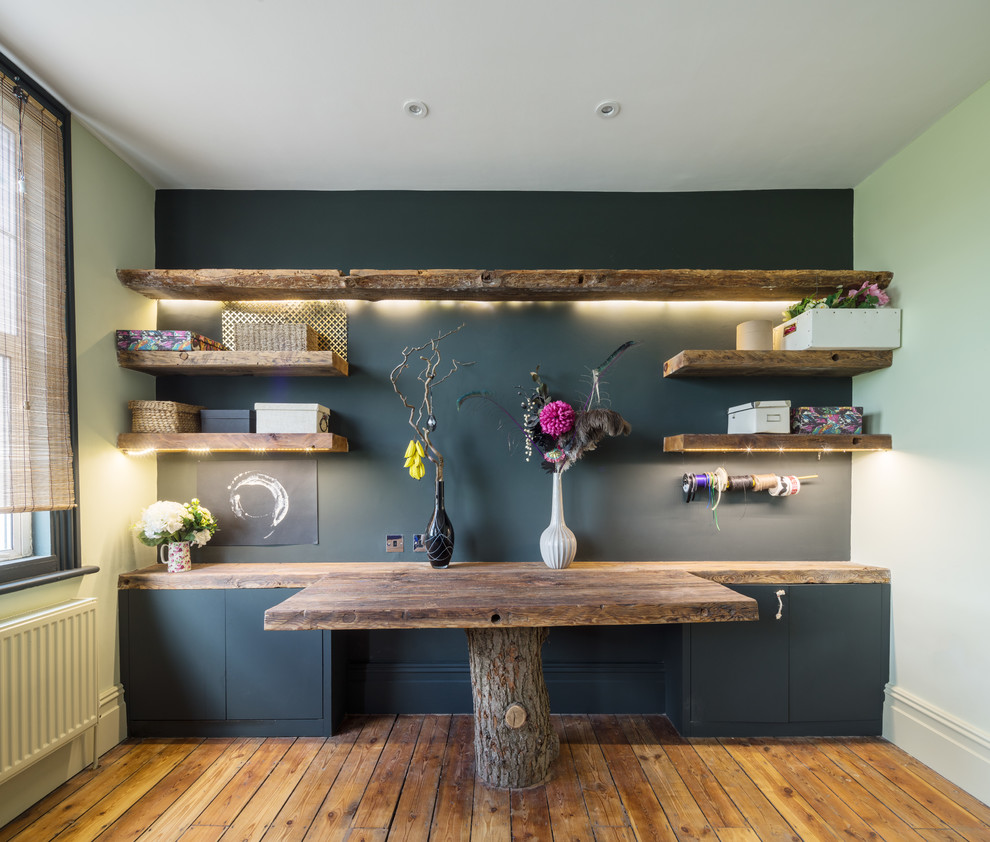 Idéer för ett mellanstort eklektiskt hobbyrum, med svarta väggar, mellanmörkt trägolv, ett inbyggt skrivbord och brunt golv