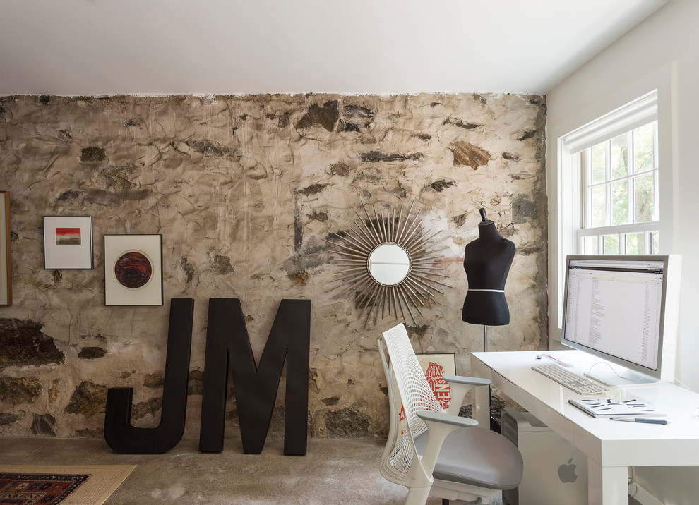 Imagen de despacho de estilo de casa de campo de tamaño medio sin chimenea con paredes multicolor, suelo de cemento y escritorio independiente