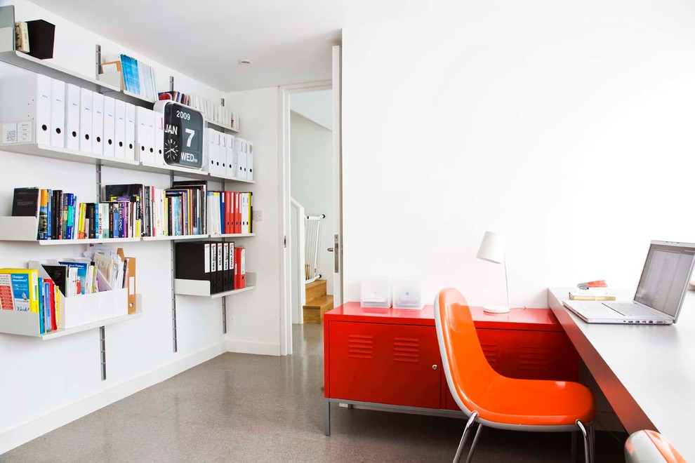 Modern inredning av ett mellanstort arbetsrum, med vita väggar och ett inbyggt skrivbord