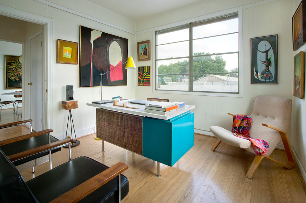 Foto på ett retro arbetsrum, med beige väggar, mellanmörkt trägolv och ett fristående skrivbord