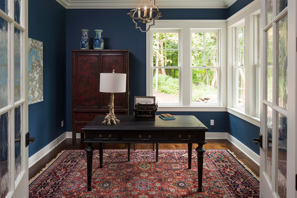 This is an example of a classic study in Minneapolis with blue walls and a freestanding desk.