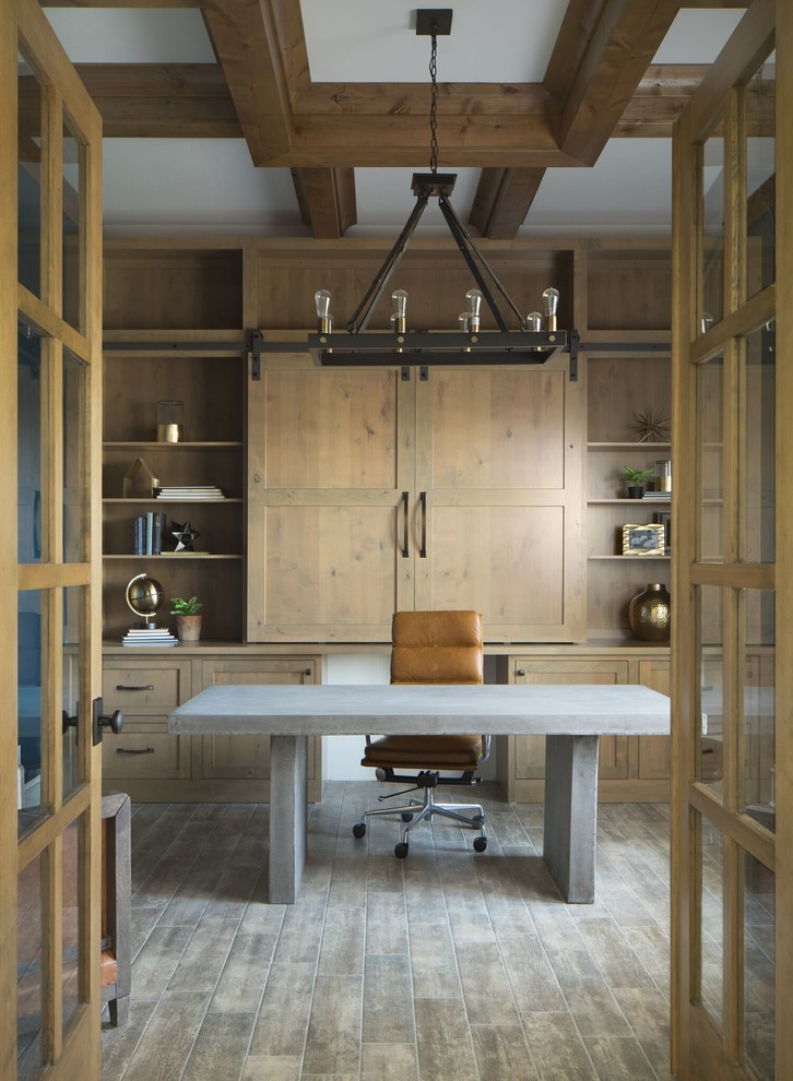 Modelo de despacho tradicional renovado con paredes marrones, escritorio independiente y suelo gris