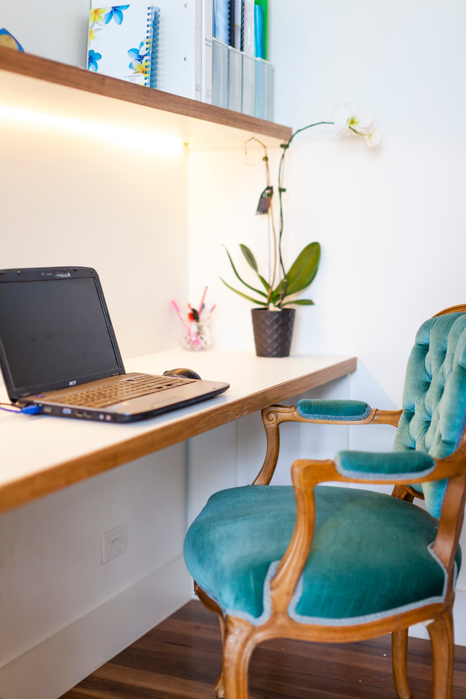 Esempio di un piccolo ufficio minimal con pareti bianche, pavimento in legno massello medio e scrivania incassata