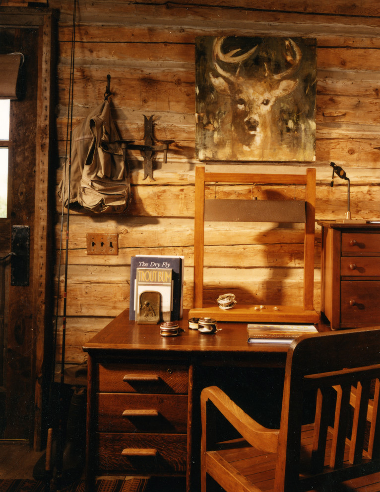 This is an example of a medium sized rustic home office in Other with dark hardwood flooring and a freestanding desk.