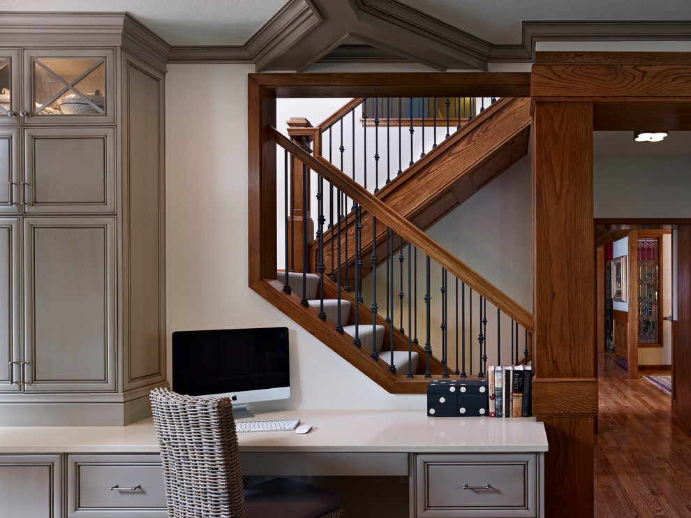 Diseño de despacho tradicional pequeño sin chimenea con paredes beige, suelo de madera en tonos medios, escritorio empotrado y suelo marrón
